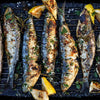 Whole Cornish sardines grilling on a barbecue