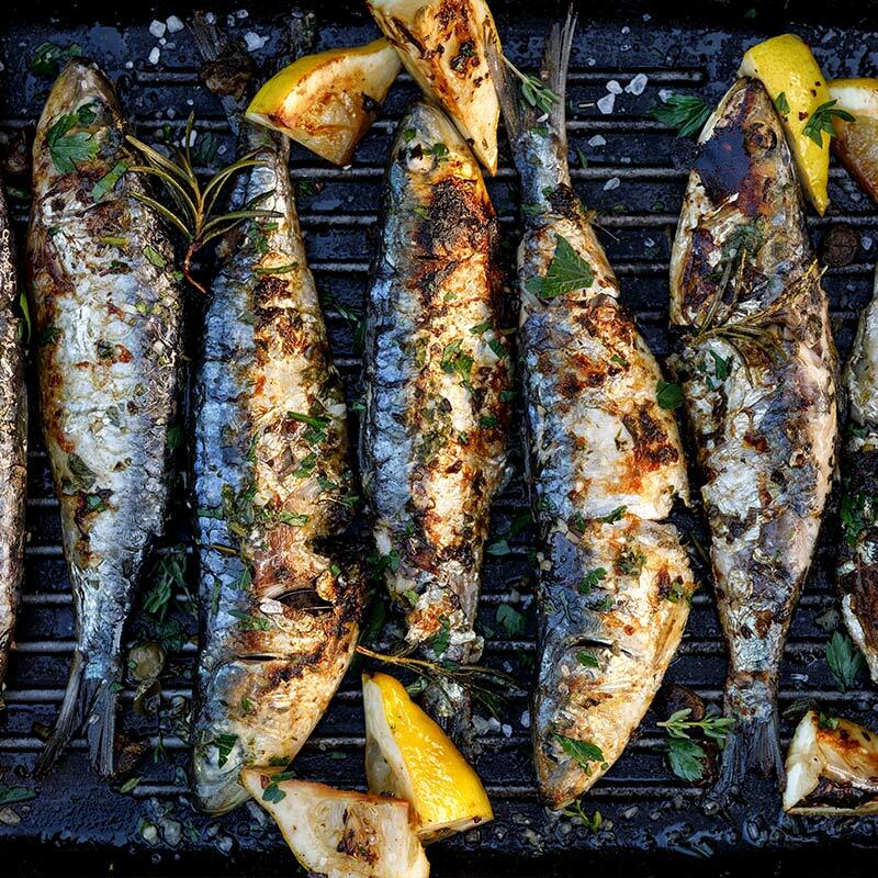 Whole Cornish sardines grilling on a barbecue