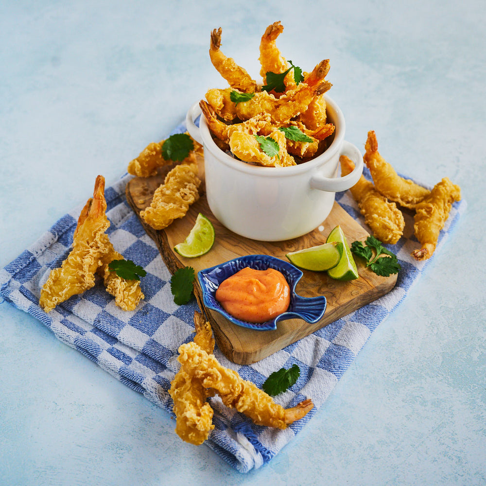 Tempura prawns in a dish on a chopping board, ready to be eaten